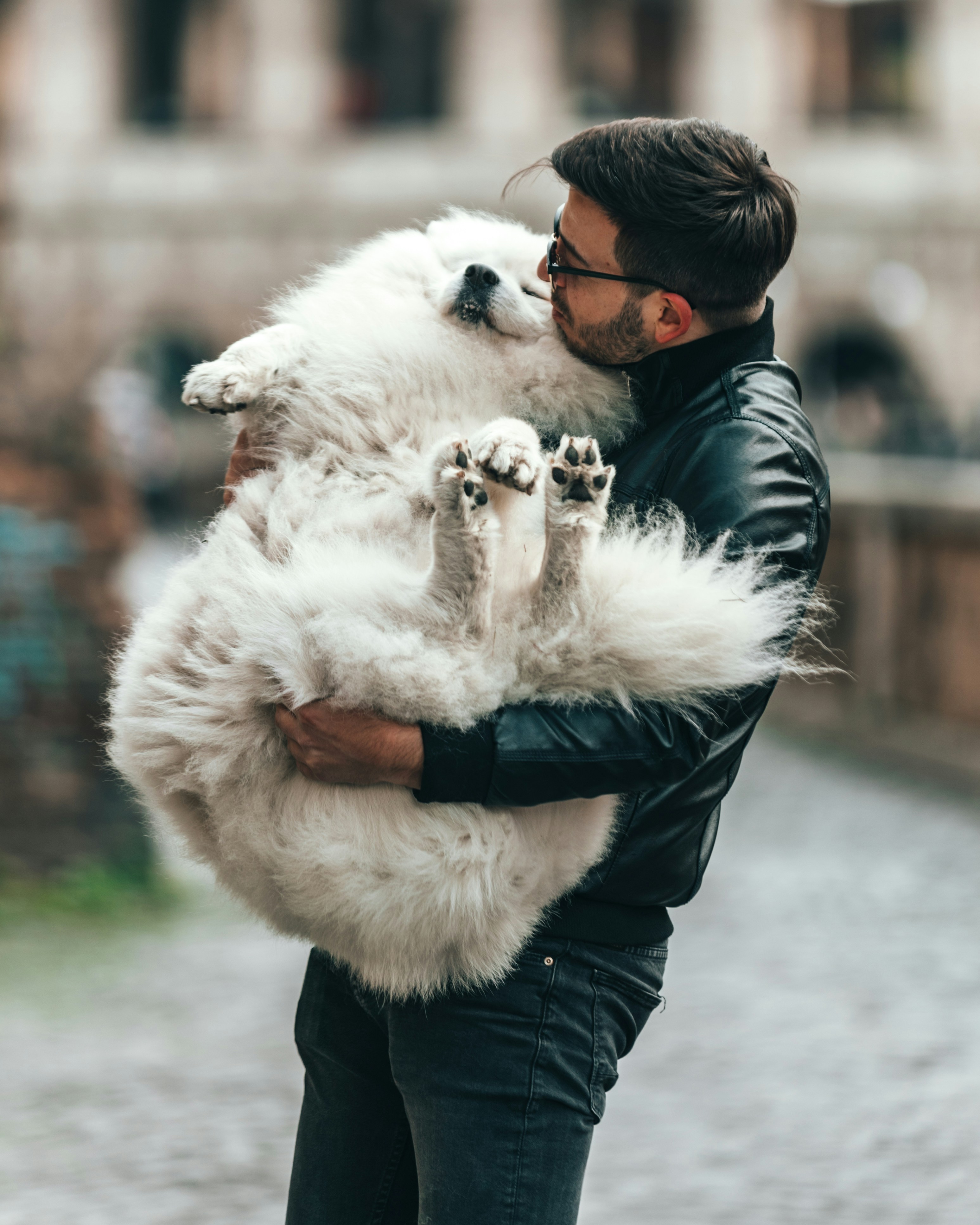 Man cradling a large fluffy white dog